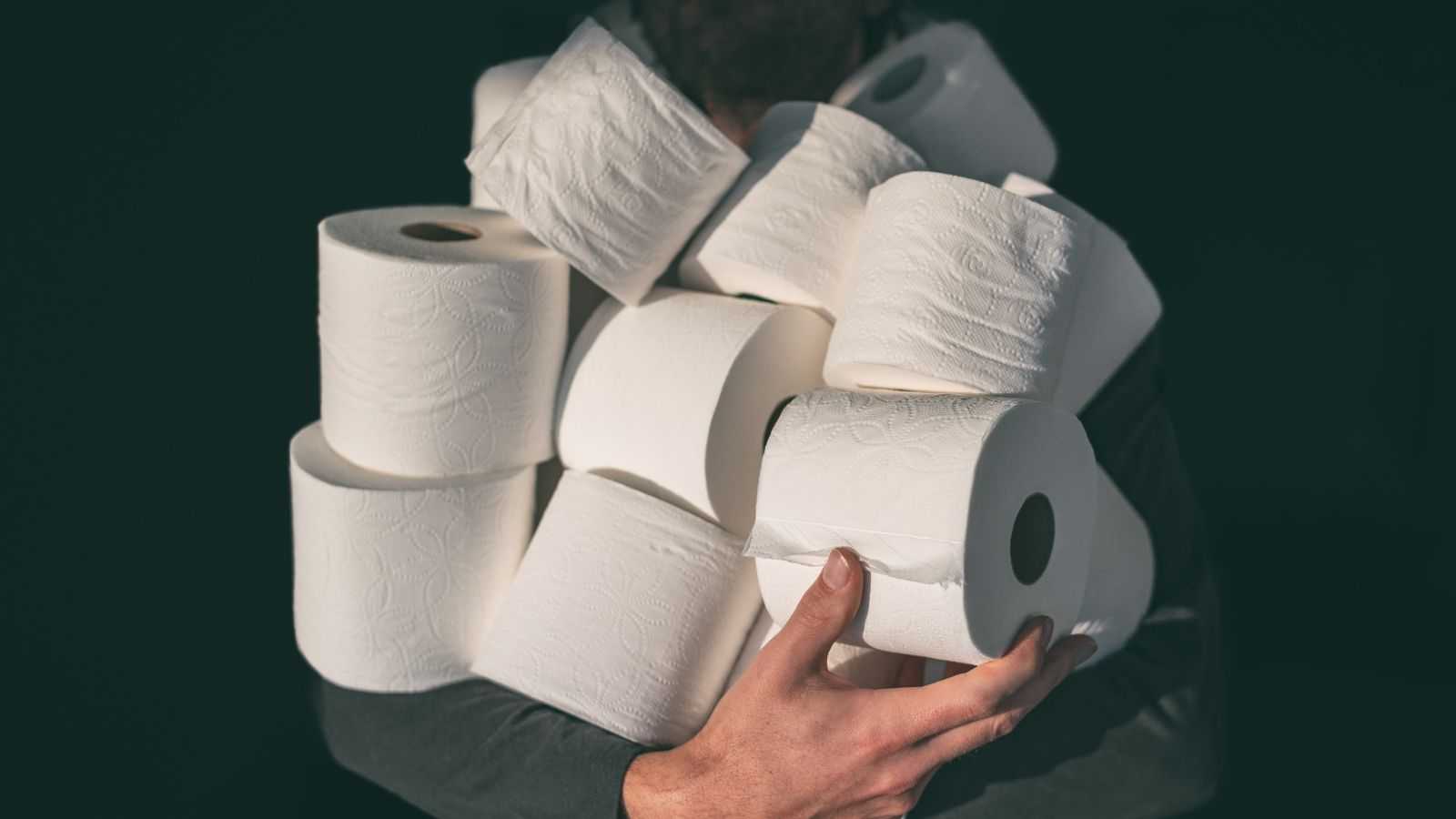 A person holding a pile of toilet paper