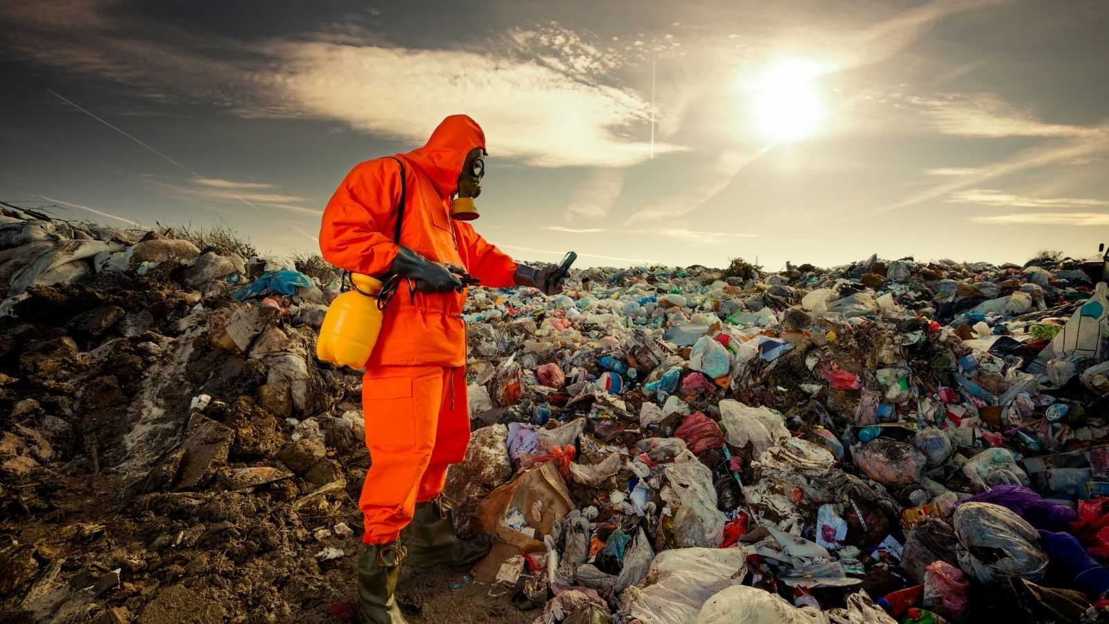 A man in a protective suit photographs rubbish